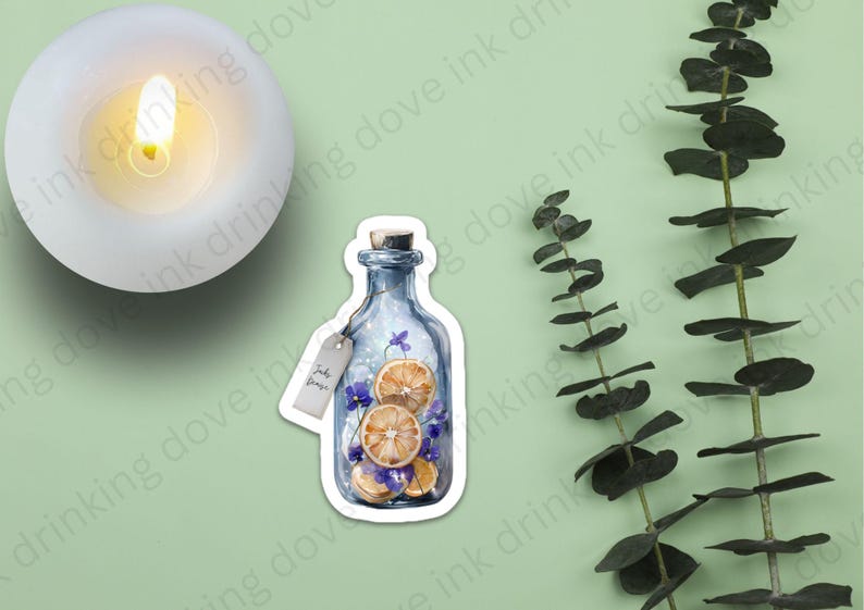 Op de afbeelding: Een blauwe glazen fles met een kurkstop, gevuld met gedroogde sinaasappelschijfjes en paarse bloemen. De fles heeft een wit label met de tekst "Just Breathe" erop.