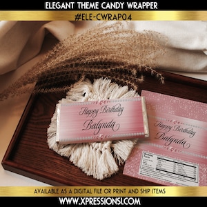 May include: Pink and white candy bar wrapper with a glittery design and the text "Happy Birthday Balynda".