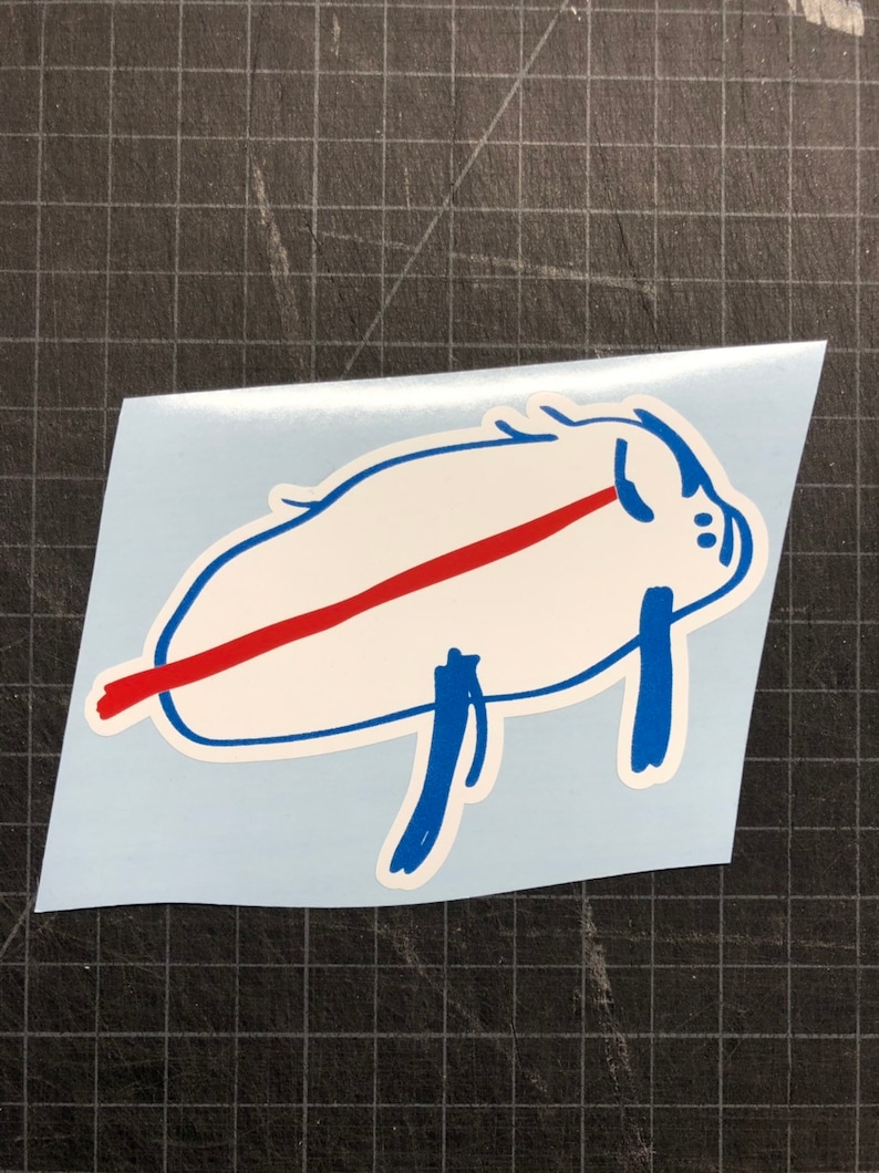 May include: A white sticker with a blue outline of a pig with a red line across its body. The pig is lying on its side with its legs in the air.