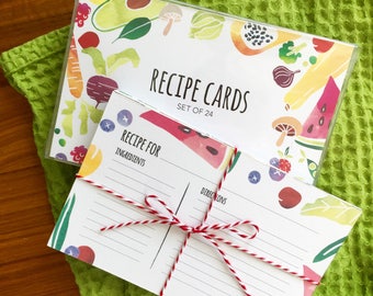 May include: A set of 24 recipe cards with a colorful fruit and vegetable design. The cards are blank and ready to be filled with your favorite recipes. The text on the cards reads "Recipe Cards, Set of 24".
