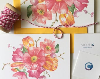 May include: A set of blank greeting cards with a watercolor floral design featuring pink and yellow flowers. The cards are tied together with red and white twine. The cards are from Studio C Design Co.