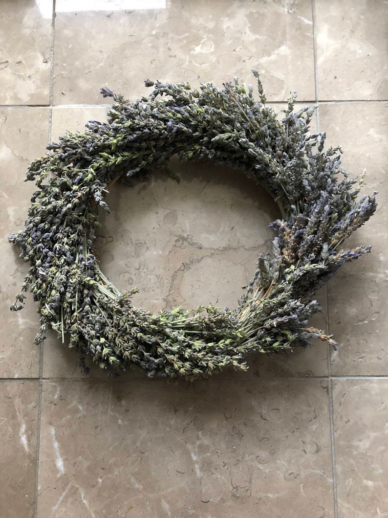 May include: A dried lavender wreath with purple and green hues. The wreath is made of natural lavender stems and is perfect for adding a touch of rustic charm to your home decor.