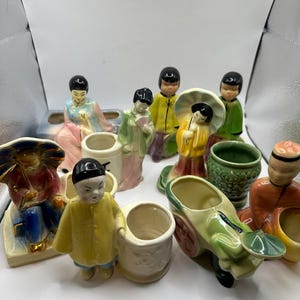 May include: A collection of 10 vintage ceramic figurines of Asian people, some holding umbrellas, some holding fans, and some holding other objects. The figurines are all in various colors, including green, yellow, blue, pink, and white. The figurines are all in different poses, and some are sitting, standing, or kneeling. The figurines are all in good condition and have no chips or cracks.