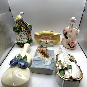May include: Six vintage ceramic wall planter vases. One is shaped like a birdhouse with a yellow bird, another is a yellow bunny face, two are shaped like violins with floral accents, and two are shaped like a dog and a bird.