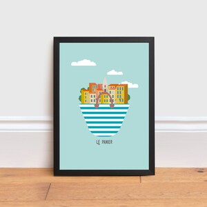 May include: A framed print of a colorful illustration of a city skyline inside a striped beach bag. The city is called "Le Panier" and is set against a light blue sky with white clouds.