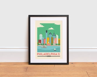 May include: A framed print of a stylized cityscape of Philadelphia, Pennsylvania. The print features a green background with a skyline of buildings in various colors, including blue, yellow, red, and white. The text "PHILADELPHIA PA" is printed in red at the bottom of the print.