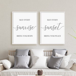Puede incluir: Dos impresiones enmarcadas blancas con texto negro. La impresión de la izquierda dice "Que cada amanecer te traiga esperanza." La impresión de la derecha dice "Que cada atardecer te traiga paz."