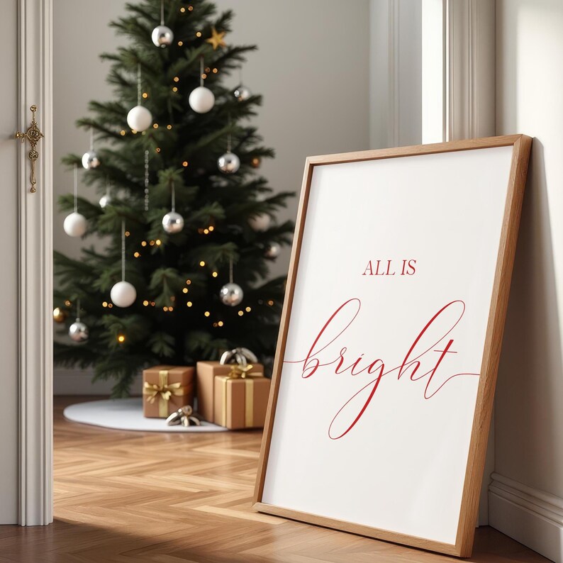 May include: A framed print with the words "ALL IS bright" in red script leans against a wall. A decorated Christmas tree with ornaments and lights is in the background. Several wrapped gifts are at the base of the tree.