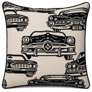 May include: A square throw pillow featuring a repeating black and white graphic pattern of vintage automobiles. The design includes various car front-end views with detailed grilles and headlights, finished with a solid black piped edge trim.