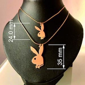 May include: Two gold necklaces with a pendant of a bunny rabbit silhouette. The longer necklace is 35 mm long and the shorter necklace is 24 mm long.