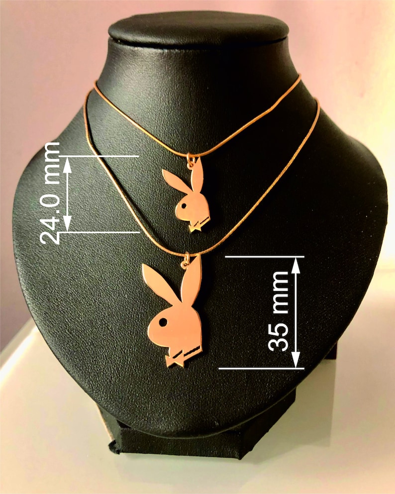 May include: Two gold necklaces with a pendant of a bunny rabbit silhouette. The longer necklace is 35 mm long and the shorter necklace is 24 mm long.