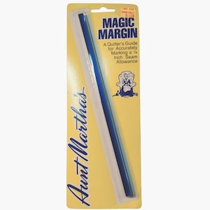 Peut inclure: Outil de quilting Magic Margin d'Aunt Martha sur une carte jaune et blanche. La carte présente du texte et une illustration d'une femme dans une chaise. L'outil est une bande de plastique bleue et blanche.