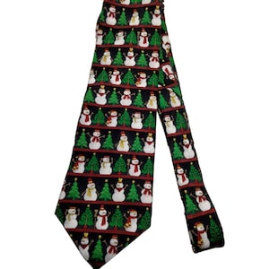 May include: A black necktie featuring a repeating pattern of white snowmen and green Christmas trees. The snowmen are depicted wearing various colored scarves and hats, arranged in horizontal rows across the fabric of the necktie.