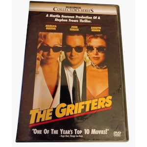 May include: A DVD case for the film The Grifters, a Miramax Collector's Series production. The cover features Anjelica Huston, John Cusack, and Annette Bening wearing sunglasses. Text includes A Martin Scorsese Production Of A Stephen Frears Thriller.