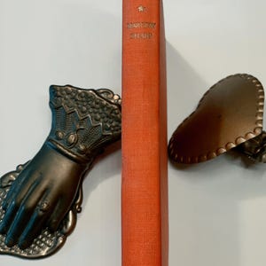 Puede incluir: La portada de un libro naranja vintage titulado "The Ingress on the Search" de Dorothy Sayers. El libro está publicado por Collins.