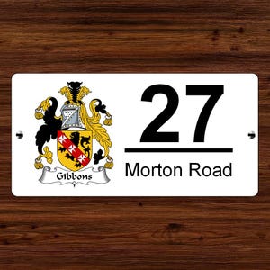May include: White house number sign with black text. The number 27 is displayed above the text "Morton Road". A coat of arms with the text "Gibbons" is displayed on the left side of the sign.