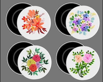 May include: Four white ceramic stovetop burner covers with black rims. Each cover features a different floral design: red and orange flowers, purple and blue flowers, pink and yellow roses, and green leaves.