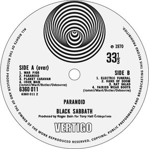May include: Black Sabbath's "Paranoid" vinyl record album cover. The cover features a black and white spiral design with the band's name and album title in white text. The record label is Vertigo Records and the catalog number is 6360 011.