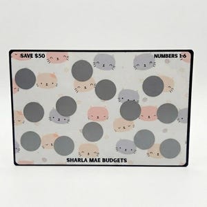 May include: A rectangular savings tracker with a black border. The tracker features a repeating pattern of cartoon cat faces in pink and gray, with gray scratch-off circles. Text includes "SAVE $50", "NUMBERS 1-6", and "SHARLA MAE BUDGETS".