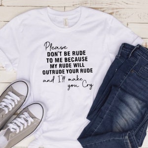 May include: A white t-shirt with the text "Please don't be rude to me because my rude will outrude your rude and I'll make you cry." The shirt is paired with blue jeans and gray sneakers.