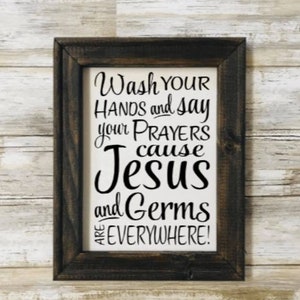 May include: A rustic wooden sign with the text "Wash your hands and say your prayers cause Jesus and germs are everywhere!"