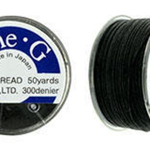 Peut inclure: Deux bobines de fil de perles noir. L'étiquette indique "One.G Made in Japan BEADS THREAD 50yards TOHO CO.,LTD. 300denier". Le fil est enroulé sur une bobine en plastique transparent avec une étiquette blanche et bleue.