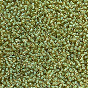 K&ouml;nnte beinhalten: Nahaufnahme eines Haufens kleiner, zylindrischer Perlen in Hellgr&uuml;n und Gold. Die Perlen sind dicht gepackt und bilden eine strukturierte Oberfl&auml;che. Die Perlen werden wahrscheinlich f&uuml;r die Schmuckherstellung oder andere Bastelprojekte verwendet.