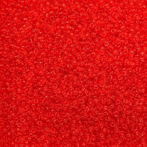 May include: A close-up of a pile of small, transparent, red beads. The beads are scattered, creating a textured surface. The color is a vibrant, translucent red, with light reflecting off the rounded edges of each bead. Suitable for jewellery making and crafts.