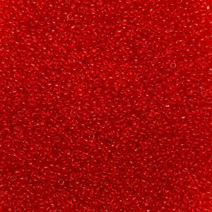 May include: A close-up of a mass of small, transparent, red glass beads. The beads are scattered, creating a textured surface. The colour is a vibrant, saturated red, with light reflecting off the rounded surfaces of the beads.