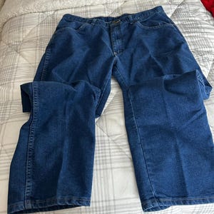 Pu&ograve; includere: Un paio di jeans blu in denim con un classico stile a cinque tasche.