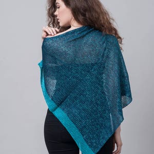 Puede incluir: Un poncho de punto azul turquesa y azul con un corte holgado y forma triangular.