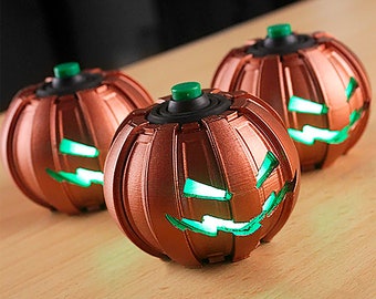 May include: Three copper-colored Halloween pumpkin-shaped ornaments with green LED lights inside. Each ornament has a black button on top.