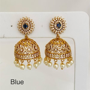 May include: Gold-toned earrings with a floral design and a blue center stone. The earrings have a bell shape, are encrusted with small, clear stones, and feature dangling white pearls. The word "Blue" is printed at the bottom.