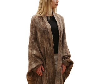 May include: A long, brown, open-front cardigan with a loose, flowing fit. The cardigan is made of a soft, textured fabric and has a slightly distressed look.