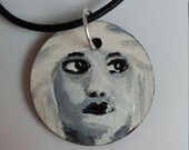 Necklace with hand-painted wooden pendant, the subject is the portrait of a black and white woman