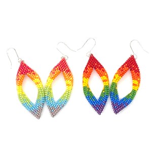May include: A pair of rainbow-colored beaded earrings with a teardrop shape. The earrings are made with small, colorful beads and have a silver hook.