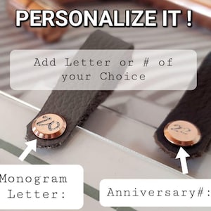 Op de afbeelding: Twee leren labels met een personalisatie-optie. E&eacute;n label heeft een monogramletter "W" en de andere het nummer "22". De tekst "Personaliseer het!" staat bovenaan de afbeelding. De tekst "Voeg een letter of # van uw keuze toe" staat onder de labels. De tekst "Monogramletter:" staat onder het linker label en de tekst "Jubileum #:" staat onder het rechter label.