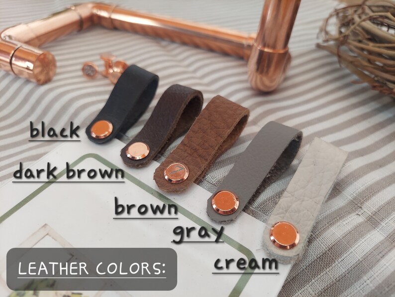 May include: Leather straps in black, dark brown, brown, gray, and cream colors. The straps have a copper rivet on each end.  LEATHER COLORS: is written on the surface below the straps.