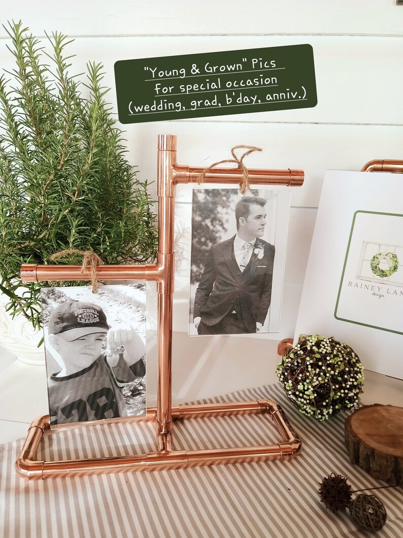 May include: Copper pipe picture frame stand with two black and white photos. The stand is on a white and brown striped surface. The text on the sign reads "Young & Grown" Pics for special occasion (wedding, grad, b'day, anniv.)