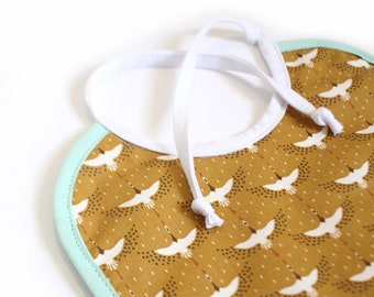 Coated cotton baby bib / Mustard cranes