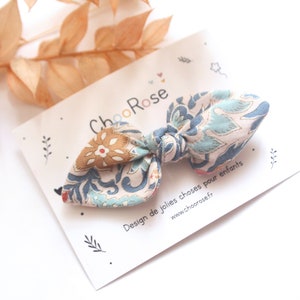 Puede incluir: Un lazo de tela con estampado azul y marrón con un nudo en el centro. El lazo está sobre una tarjeta blanca con el texto "ChooRose Design de jolies choses pour enfants www.choorose.fr"