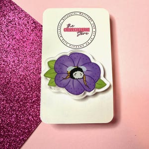 May include: A purple flower with a bee inside. The bee is yellow and black with white wings. The flower is surrounded by green leaves. The image is on a white background with the text "The Curvecreation Store" in a pink circle.