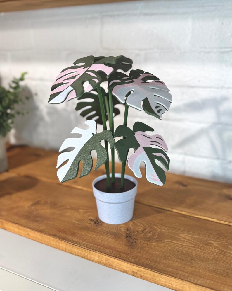 May include: A set of three ceramic mugs with a speckled, matte finish. The mugs are in shades of cream, light gray, and dark gray. Each mug has a simple, minimalist design and a rounded handle.