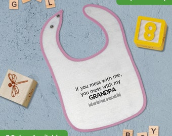 May include: Pink baby bib with a white background and pink trim. The bib has a saying on it that reads "If you mess with me, you mess with my GRANDPA (and you don't want to mess with him)"
