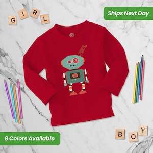 May include: Red long-sleeved shirt with a robot graphic. The robot is green, blue, and brown with a spring antenna. The shirt has a crew neck.