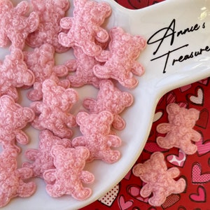 May include: A white ceramic plate with a pink heart design on the edge, filled with pink fuzzy teddy bear shapes. The plate has the text "Annie's Treasures" written on it.