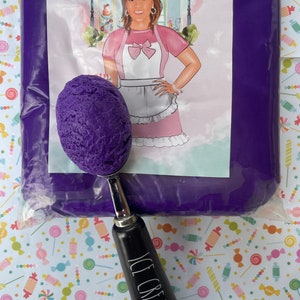 May include: A purple scoop of ice cream in a black ice cream scoop with the words "ICE CREAM" on the handle. The ice cream is in a clear plastic bag with a purple background and the words "Annie's Treasures" on the front.