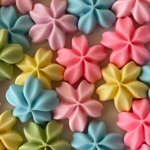 May include: Assortment of pastel-colored sugar cookies shaped like five-pointed stars. The cookies are in shades of pink, blue, yellow, and green.