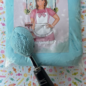 May include: A scoop of blue ice cream in a silver ice cream scoop with a black handle that reads "ICE CREAM". The ice cream is next to a bag of blue material with a label that reads "Arrie's Treasures". The background is a colorful candy pattern.