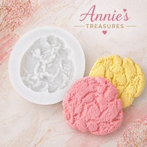 May include: A white silicone mold and two textured, flower-shaped soaps in pink and yellow. The soaps and mold are on a light pink marble surface. The text "Annie's Treasures" is at the top of the image.